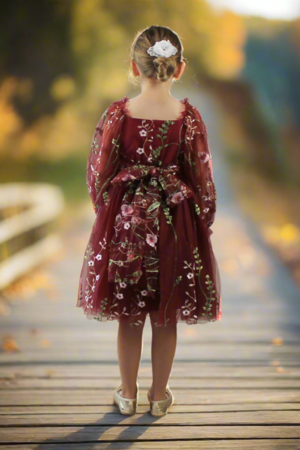 Burgundy floral long sleeve flower girl dress made in a knee length style.