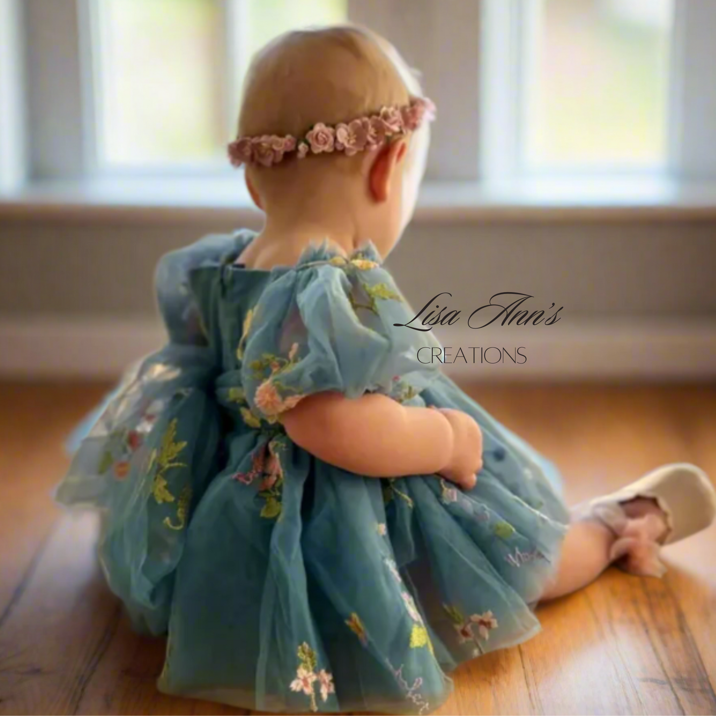 baby girl wearing a dusty blue floral tulle dress for her first birthday party.