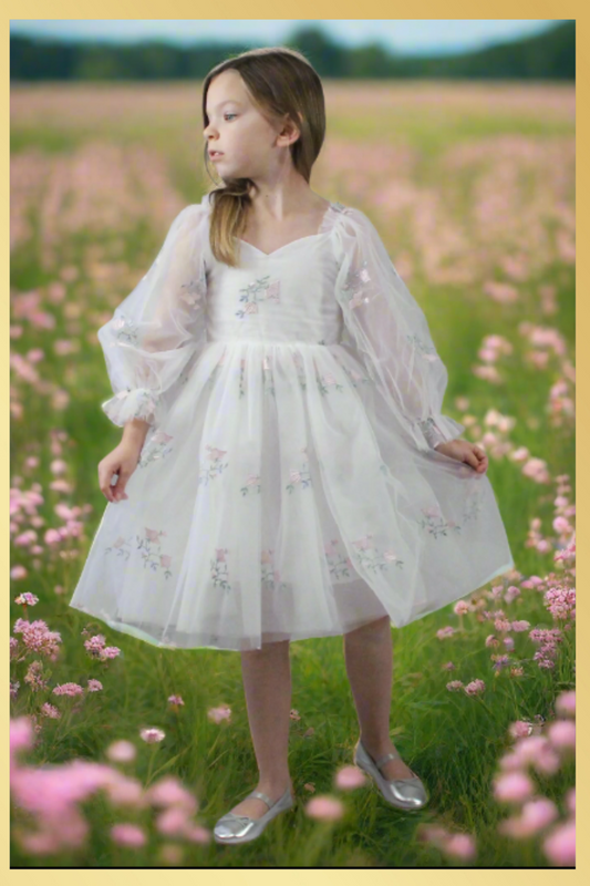 Girls party dress in long sleeves. Made with a soft white tulle with a tulip embroidery flower. Made to be knee length and perfect for parties, weddings, and all special occasions.
