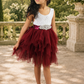 flower girl dress in a tiered tutu style. Burgundy knee length tulle and white sleeveless bodice. 