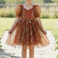 Flower Girl Dress in burnt orange floral with puffy sleeves and big bow tie in back of dress. Beautiful floral tulle