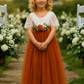 flower girl dress in burnt orange with short white lace sleeves and flowing tulle