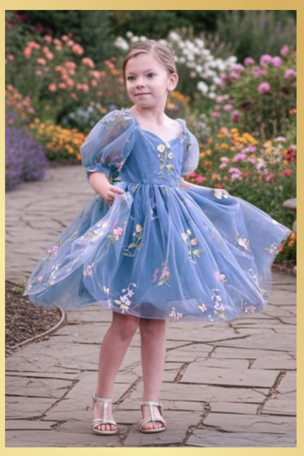 floral dress in dusty blue tulle with embroidered flowers and butterflies all over the dress. In a puff sleeve and knee length style. Prefect for an upcoming wedding or birthday. 