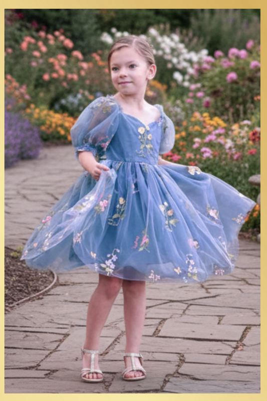 floral dress in dusty blue tulle with embroidered flowers and butterflies all over the dress. In a puff sleeve and knee length style. Prefect for an upcoming wedding or birthday. 