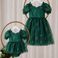 Baby dress for Christmas in green candy cane tulle with puff sleeves, sweetheart neckline and short bodysuit-style design.