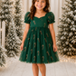 Christmas baby girl dress featuring green tulle, red and gold candy canes, puff sleeves and a short skirt over a built-in bodysuit.