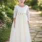 Tulle Flower Girl Dress in ivory with long lace sleeves and flowing full-length skirt for weddings