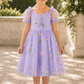 Flower girl dress in embroidered lavender floral tulle. Short puffy sleeves with big bow tie in back.  