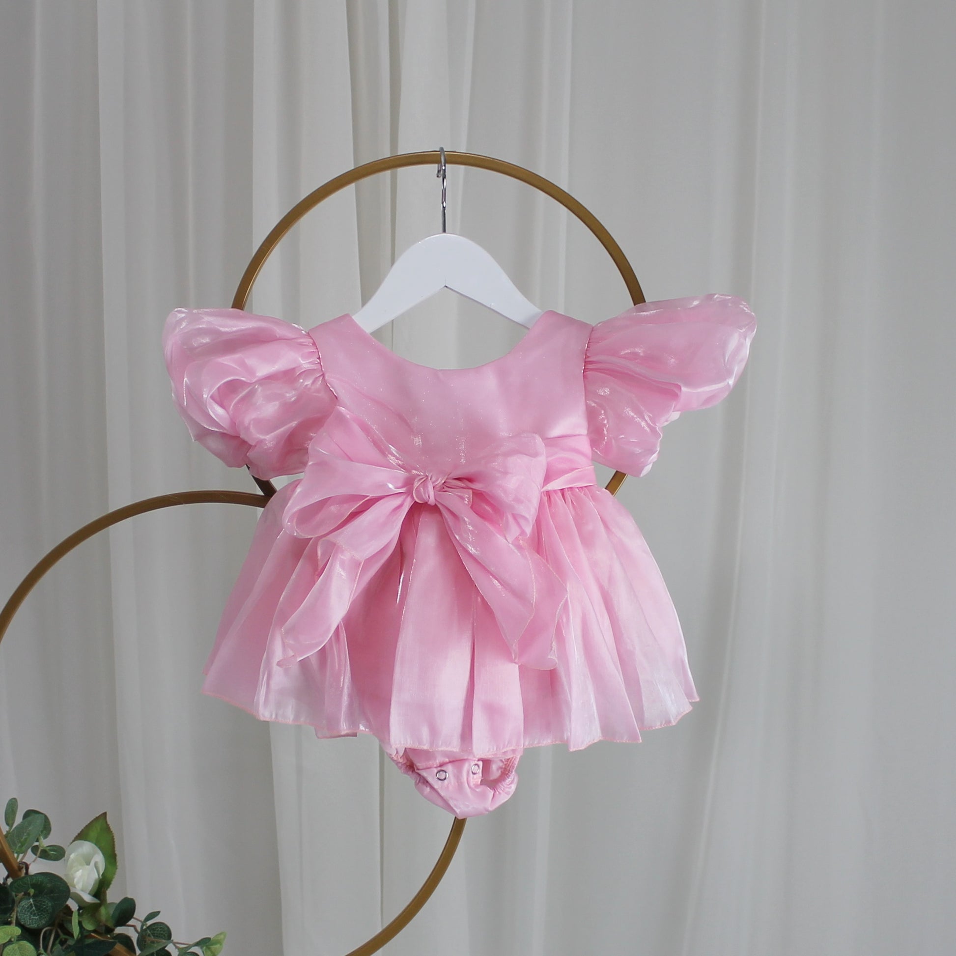 light pink baby girl dress with puffy sleeves and big bow for birthdays and special occasions. 