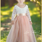 Flower girl dress in a light peach tulle with a long sleeve white lace top. 