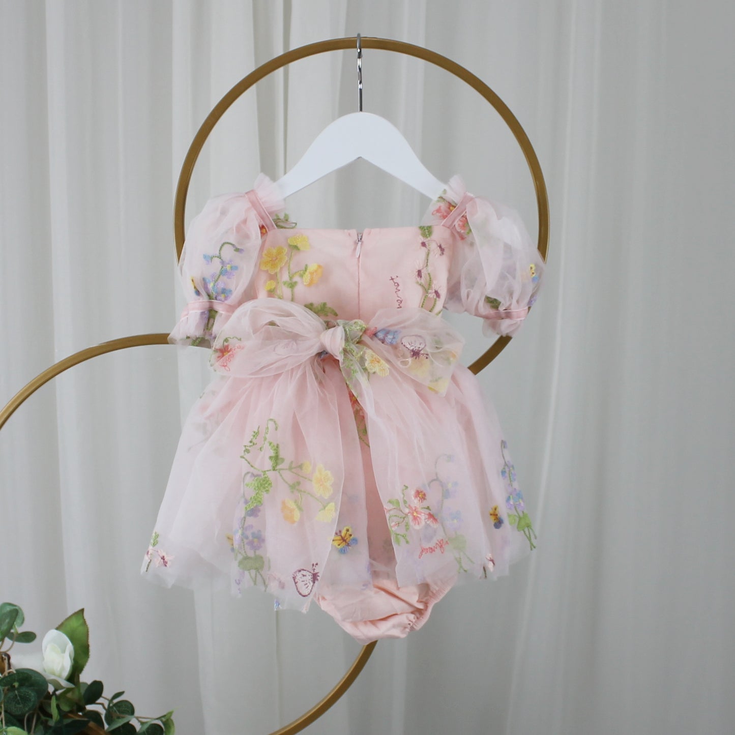 1st birthday baby girl romper in light pink floral for a fairy or garden party theme. 