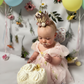 1st birthday baby girl romper in light pink floral for a fairy or garden party theme. 