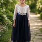 flower girl dress in navy blue tulle with white lace long sleeves in an ankle length style. 