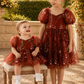 wildflower flower girl dress in a rust embroidered floral knee length dress with big puffy short sleeves. 