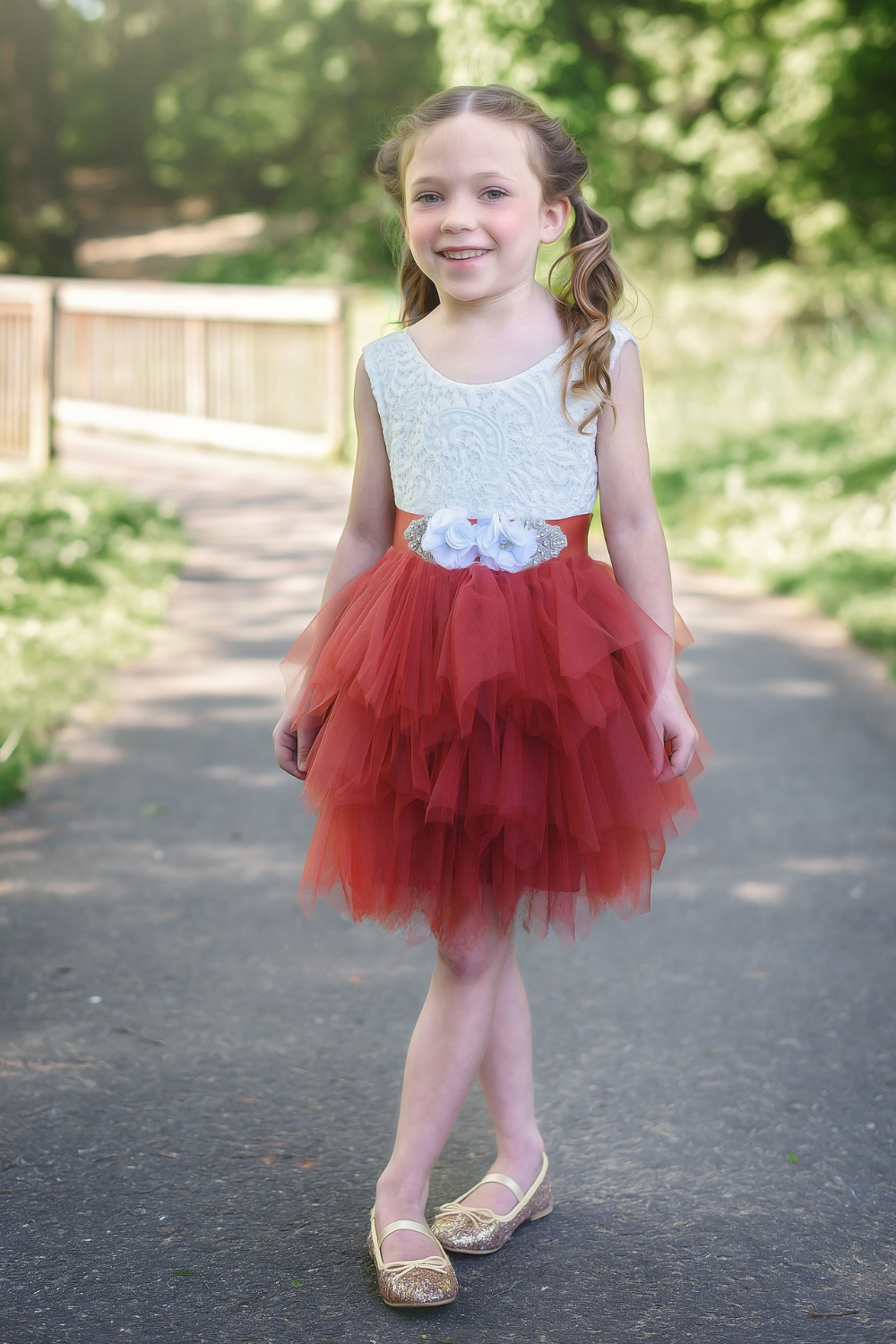 Flower girl dress in rust tulle tiered tutu style with white lace sleeveless top. 