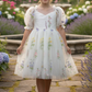 White floral flower girl dress with big puffy sleeves and big bow in back. 
