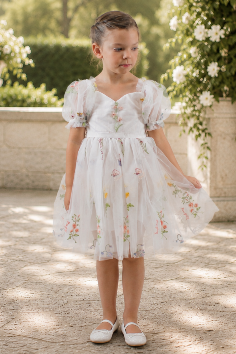 wildflower flower girl dress in white embroidered florals, knee length style dress with big puffy short sleeves. 
