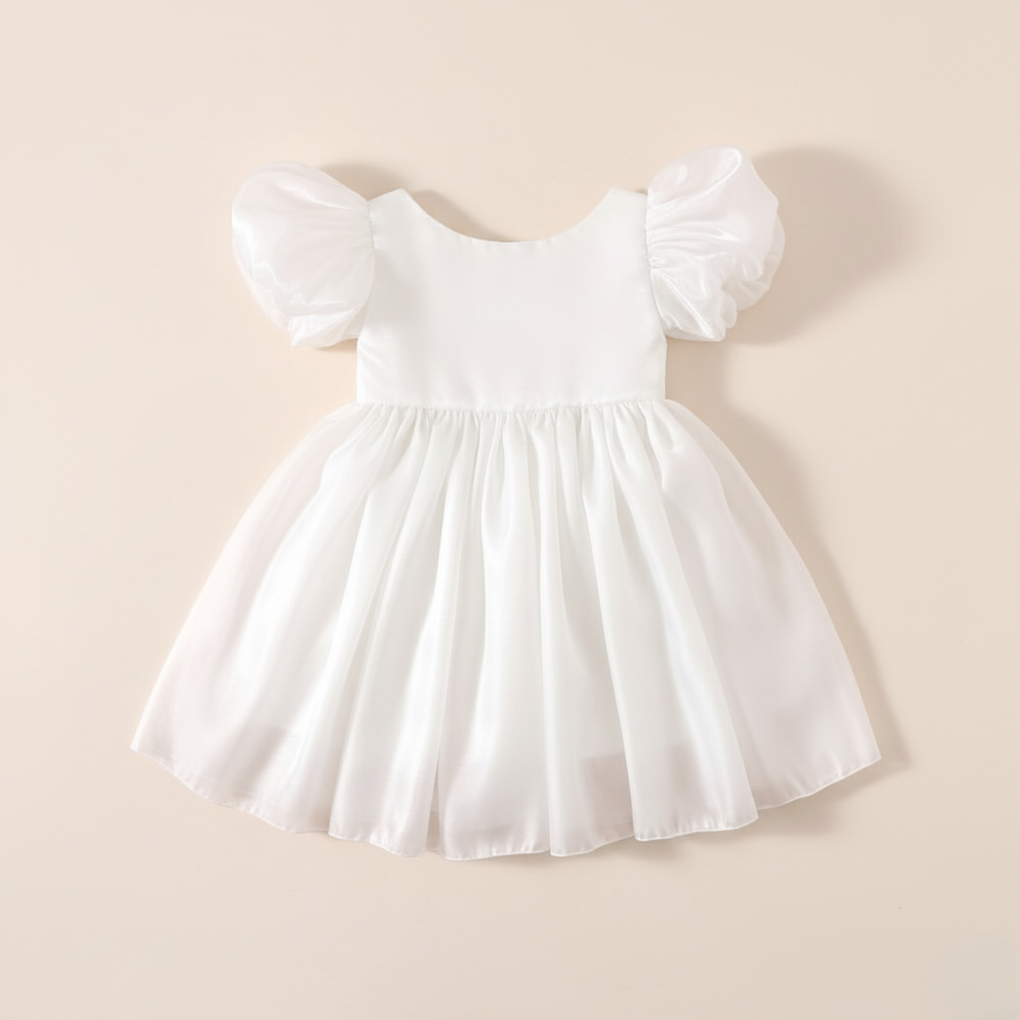 Girls white Christmas romper dress for holiday parties and family photos. In a short puffy sleeve style with shiny organza material for a knee length style