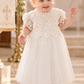 white christening dress in short sleeves and tulle. 